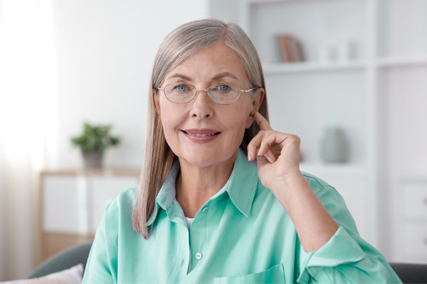 woman touching hearing aid